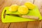 Peeled potatoes, knife on cutting board on wooden table