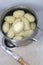 Peeled potatoes in a saucepan in a kitchen sink.