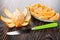 Peeled tangerine, knife, slices of tangerine in plate on wooden table