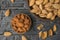 Peeled and unpeeled almonds in two bowls on a wooden table. Flat lay