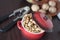 Peeled walnuts in a small red saucepan with a nutcracker