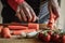 Peeling and slicing carrots close up. Girly hands preparing food