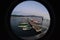 Peephole view of a small port with boats in the water