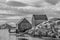 Peggy`s Cove, Nova Scotia fishing sheds with rocky cliffs iin black and white.