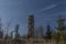 Pekelsky hill with observation tower and flying airplane and blue sky