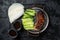 Peking Duck served with cucumber, green onions, and roasted wheaten chinese pancakes with sauce Hoysin. Black background