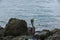 Pelican sitting on rock. Turquoise water and blue sky background. Caribbean. Aruba.