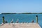Pelicans - and other birds - on the end of the pier with the bay and fishing boats and kayaks on the water in the Florida Keys