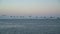 Pelicans over the Pacific Ocean flying by Bay Bridge in the background