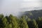 pemandangan kabut melintasi bukit pegunungan di pagi hari
