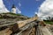 Pemaquid Point Lighthouse sits atop rugged rock layers on a bright summer day dotted with puffy clouds