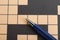 Pen on blank crossword, top view. Intellectual entertainment