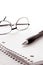 Pen and Glasses on Notebook Blank Paper Sheet