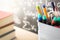 Pen holder and books in front of blackboard in classroom.