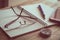 Pen, notebook, compass, glasses and mobile phone on wooden table