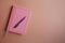 Pen on pink notebook or diary, on paper background