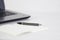 A pen on table desk with laptop and notepad with empty space background for design.