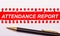 Pen and white torn paper strip on a bright red background with the text ATTENDANCE REPORT