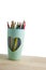 Pencil color group in green cup on the wooden table