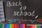Pencils, clips, notebook and the title Back to school written by white chalk on the black school chalkboard