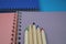 Pencils crayons lying on wire bound open notebook