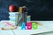 Pencils, multicolored letters, stack of books and apple on school board background