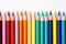 pencils organized by color spectrum on a white desk surface