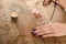 The pendulum on a chain with a natural crystal in hands on a background of wood texture