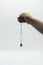 Pendulum dowsing on an isolated white background with an amethyst crystal and colored chakra stones