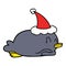 penguin lying on belly wearing santa hat