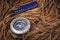 Penknife and compass on forest floor of pine needles