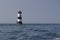 Penmon point lighthouse in the menai straits, Anglesey. Black and white lighthouse on a summer day