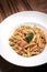 Penne amatriciana tomato and ham sauce pasta on wood table