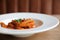 Penne arrabiata pasta tomato sauce with spices italian food on wood background