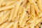 Penne lisce - traditional italian pasta of durum wheat, food background