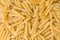 Penne pasta background - top view, raw penne pasta texture background, close up raw penne rigate pasta uncooked delicious pasta