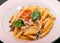 Penne pasta in cheese sauce with beef meat, tomatoes, parmesan