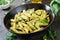 Penne pasta with pesto sauce, zucchini, green peas and basil.