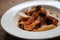 Penne pasta tomato sauce arabiata with seafood on wood background vintage style