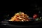 Penne pasta with tomato sauce on a black plate on black background. Traditional Italian pasta. Italian food