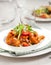 Penne pasta in tomato sauce with chicken, parsley in pan. Chicken italian penne pasta over black background with copy space, ital