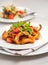 Penne pasta in tomato sauce with chicken, parsley in pan. Chicken italian penne pasta over black background with copy space, ital