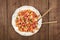 Penne pasta with tomato sauce, fork and spoon plunged into plate