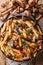 Penne pasta with wild mushrooms honey fungus, tomatoes, cheese and parsley close-up in a plate. Vertical top view