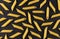 Penne rigate pasta pattern on black background, top view, flat lay texture