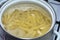 Penne rigate pasta in a pot of boiling water on a gas stove. Cooking pasta
