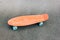 penny board on the asphalt. small plastic skateboard. pink penny Board with blue wheels