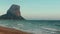 Penon de Ifach, Calpe, Spain. Seascape sea waves, sandy beach and rocky mountain