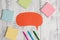 Pens ballpoints blank colored speech bubble sticky notes lying wooden rustic vintage background. Empty text announcement