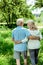 Pensioner hugging happy senior wife in green park
